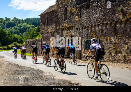 Group of cyclists passing Tretower Court & Castle in the Brecon Beacons National Park Wales Stock Photo