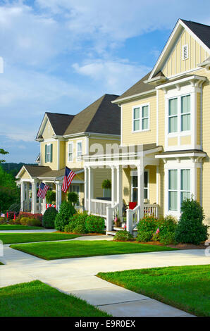 American Flags hang from the front porches in a neighborhood of upscale, Victorian homes in celebration of the upcoming holiday. Stock Photo