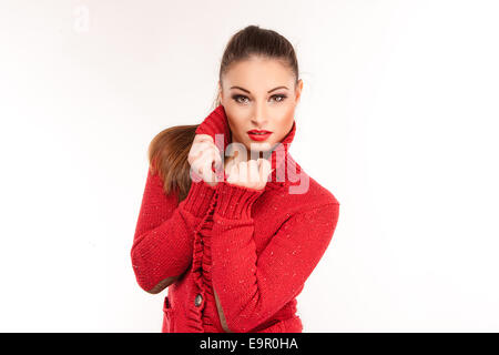 Portrait of a young attractive woman in red sweater trying to keep warm Stock Photo