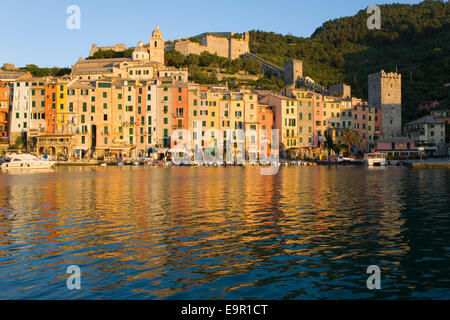 Portovenere, Liguria, Italy. View across the harbour to colourful houses, sunrise. Stock Photo