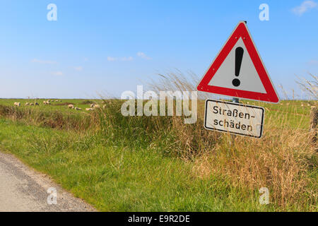 German road sign in the countryside warning of road damage Stock Photo