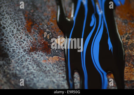 Blue and black paint on a rusted metal surface Stock Photo
