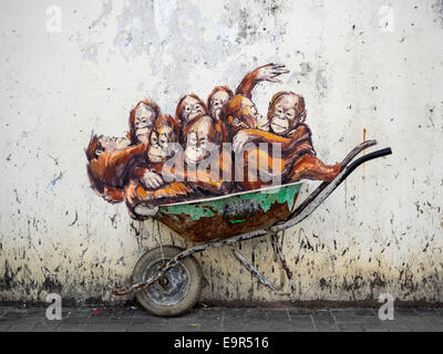 Orangutans in a Wheelbarrow street art mural by Lithuanian artist Ernest Zacharevic in Kuching, Sarawak, East Malaysia. Stock Photo