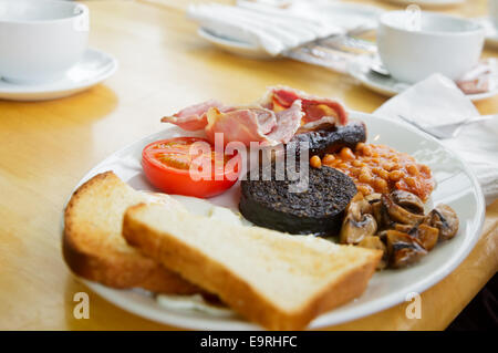 Plate with Full Scottish breakfast containing  toasts, fried eggs, baked beans, grilled black pudding, sausage, tomato,  mushroo Stock Photo