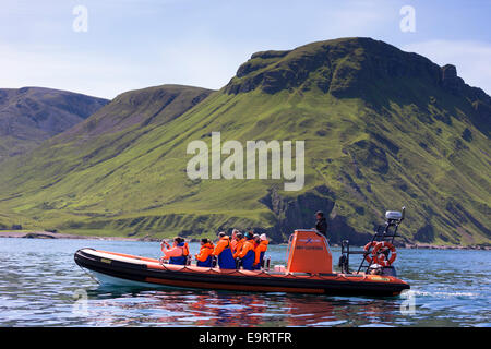 Rigid inflatable tourist sealwatching boat trip on visit to Isle of Canna part of the Inner Hebrides and Western Isles in West C Stock Photo