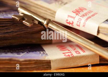 Bundles of cash and keys depicting a house deposit concept Stock Photo