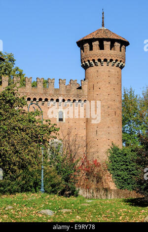 The tower of the medieval castle in the Valentino Park, Turin (Italy), surrounded by vegetation with the background of blue sky Stock Photo