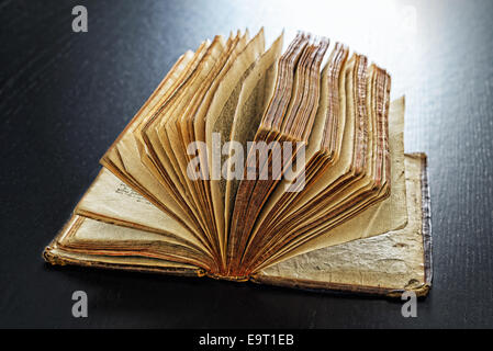 Backlit antique book on a dark table closeup Stock Photo