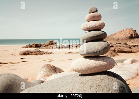 Balanced stones in retro style on the beach Stock Photo