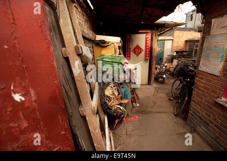 A cluttered courtyard corner with red paint, bicycles and chinese new year decorations, hutong area, Beijing, China Stock Photo