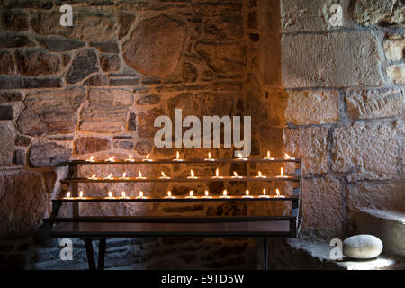 Flames of votive candles for prayer inside Iona Abbey ancient monument on Isle of Iona in the Inner Hebrides and Western Isles, Stock Photo