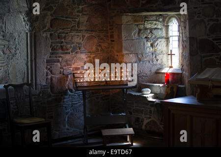 Flames of votive candles for prayer inside Iona Abbey ancient monument on Isle of Iona in the Inner Hebrides and Western Isles, Stock Photo