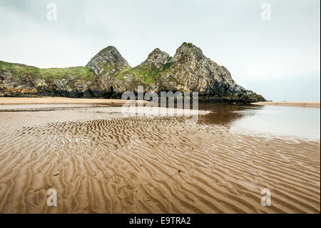 Three Cliffs bay in Wales UK, Image taken of the rock formations within the bay and the ripples in the sand left by the sea. Stock Photo