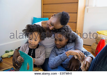 Mother and children reading story in bedroom