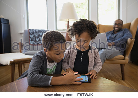 Brother and sister sharing digital tablet