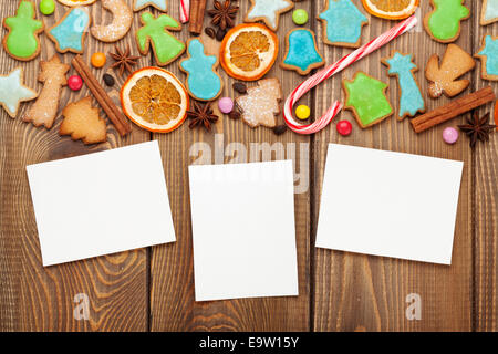 Christmas wooden background with photo frames, candies, spices and gingerbread cookies Stock Photo
