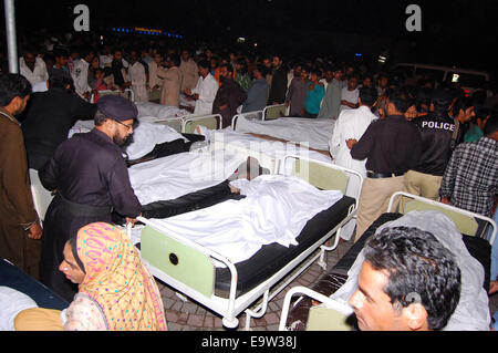 Lahore. 2nd Nov, 2014. Pakistani relatives gather around the bodies of blast victims at a hospital after a suicide bomb attack near Wagah border in eastern Pakistan's Lahore on Nov. 2, 2014. Death toll rose to 54 and over 100 others were injured in the Sunday evening's suicide blast that took place near Wagah border crossing in Pakistan's eastern city of Lahore, hospital sources said. Credit:  Xinhua/Alamy Live News Stock Photo