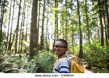 Portrait of smiling boy with backpack in woods