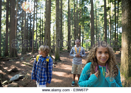 Boys and girl with backpacks in woods