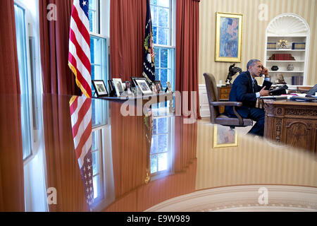 President Barack Obama talks on the phone with President Franois Hollande of France in the Oval Office, Aug. 9, 2014.   Ph
