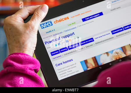 Care Home, Care Services screen on NHS Choices Website, Woman reading Browsing Web Site for Care Homes Stock Photo