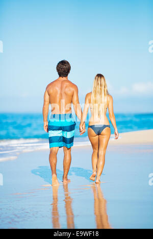 Attractive Happy Couple Walking on Sandy Beach Stock Photo