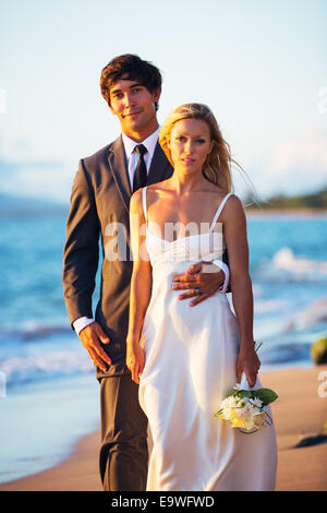 Beautiful Wedding Couple, Bride and Groom on the Beach at Sunset Stock Photo