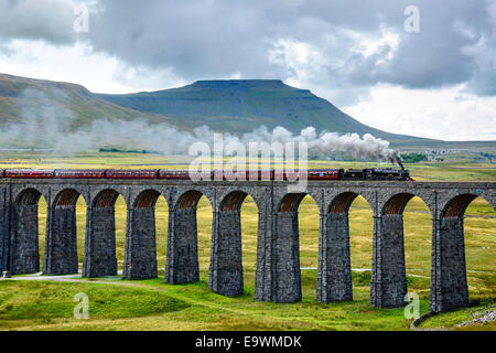 Steam train crossing the Ribblehead Viaduct on the Settle-Carlisle railway line with Ingleborough behind Stock Photo