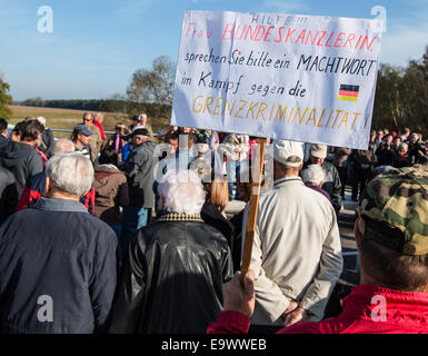 Guenter Fromm (R) from Eisenhuettenstadt protests at the opening celebrations of the new bridge between Germany and Poland over the Neisse River in Coschen, Germany, 03 November 2014. His sign, which reads, 'In Coschen we built a bridge for the gang of thieves.' refers to the crime rate in the German border region. Seventy years later there is finally another bridge over the Neisse, connecting Coschen with Poland. The original bridge was destroyed in the Second World War. The basis for the construction comes from a government agreement between Germany and Poland. From the total costs of 5.4 Stock Photo