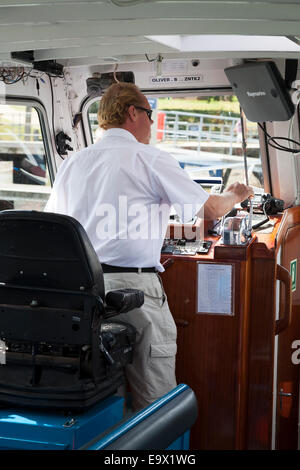 Skipper operating controls of motor boat river cruiser Stock Photo