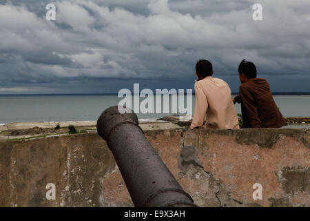 Young people relax at the wall of Fort Marlborough, an 18th English century fort located in Bengkulu City, Bengkulu, in Sumatra Island, Indonesia. Stock Photo