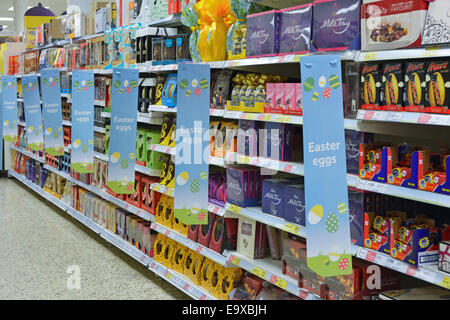 Chocolate Easter Eggs seasonal products on sale on shelves inside Tesco retail business supermarket store Interior view East London England UK Stock Photo