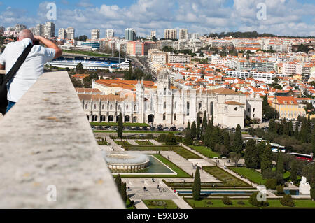 Horizontal view of a man taking photographs of Jeronimos Monastery and surrounding gardens in Belem, Lisbon. Stock Photo
