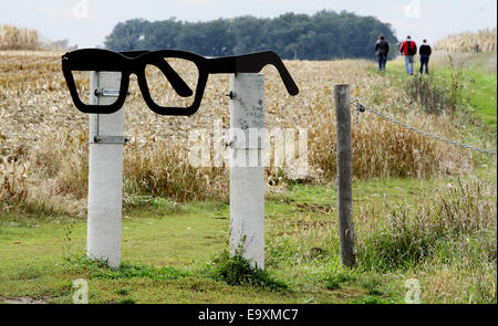 Clear Lake, IOWA, USA. 5th Oct, 2014. At the intersection of Gull Avenue and 315th Street North of Clear Lake, Iowa is giant pair of glasses making the nearest roadside location to the Buddy Holly plane crash site. Following the fence about a 1/2 mile down a dirt path into a cornfield to the memorial where the plane carrying Buddy Holly, Ritchie Valens and J.P. ''The Big Bopper'' Richardson crashed killing all aboard on Feb. 3, 1959. The three young singers were in a single-engine aircraft flying in a light snowstorm in 1959 when the pilot apparently lost control. Holly decided to fly because Stock Photo