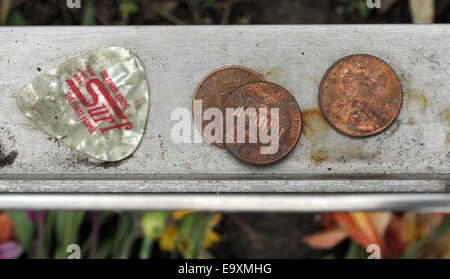 Clear Lake, IOWA, USA. 5th Oct, 2014. A guitar pick and three pennies sit on the back ledge of a memorial at the spot where the plane carrying Buddy Holly, Ritchie Valens and J.P. ''The Big Bopper'' Richardson crashed killing all aboard on Feb. 3, 1959, North of Clear Lake, Iowa. The three young singers were in a single-engine aircraft flying in a light snowstorm in 1959 when the pilot apparently lost control. Holly decided to fly because his tour bus was having heating problems. © Kevin E. Schmidt/ZUMA Wire/Alamy Live News Stock Photo