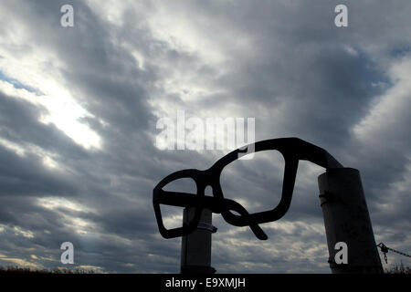 Clear Lake, IOWA, USA. 5th Oct, 2014. At the intersection of Gull Avenue and 315th Street North of Clear Lake, Iowa is giant pair of glasses making the nearest roadside location to the Buddy Holly plane crash site. Following the fence about a 1/2 mile down a dirt path into a cornfield to the memorial where the plane carrying Buddy Holly, Ritchie Valens and J.P. ''The Big Bopper'' Richardson crashed killing all aboard on Feb. 3, 1959. The three young singers were in a single-engine aircraft flying in a light snowstorm in 1959 when the pilot apparently lost control. Holly decided to fly because Stock Photo