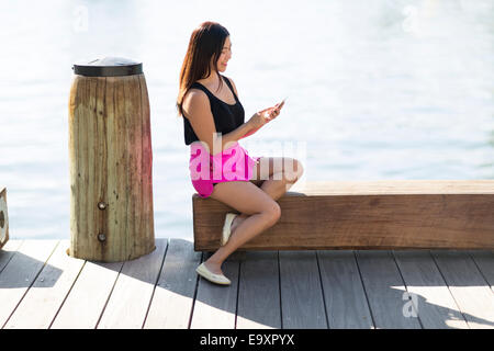 A young Asian woman using a smartphone to communicate Stock Photo