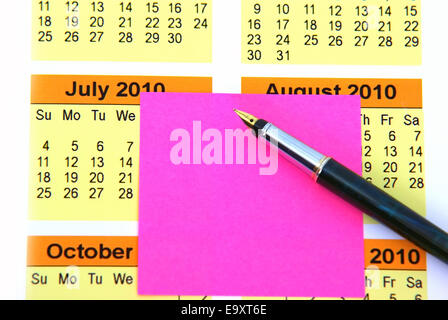Making a note on a pink adhesive notes. Stock Photo