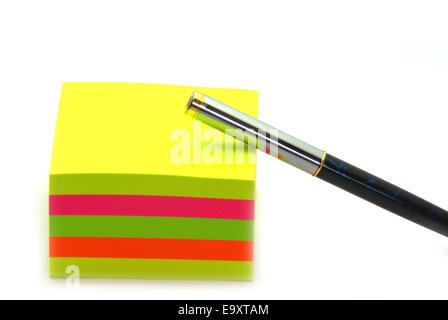 Stack of sticky notes and a pen on a white background. Stock Photo