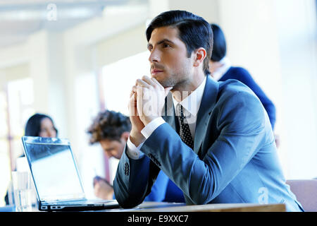 Portrait of a pensive businessman sitting at the table in office Stock Photo
