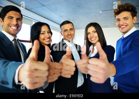 Portrait of happy young business people with thumbs up sign Stock Photo