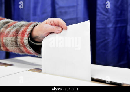 Close-up of a person hand putting a vote in the ballot box Stock Photo