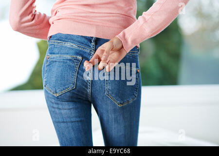 Woman with fingers crossed behind her back