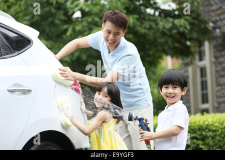 Boy and girl helping father cleaning car Stock Photo