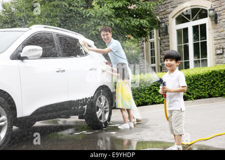 Boy and girl helping father cleaning car Stock Photo