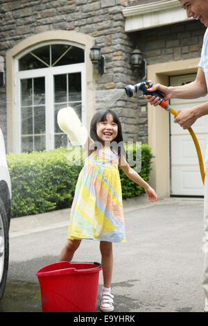 Girl helping father cleaning car Stock Photo