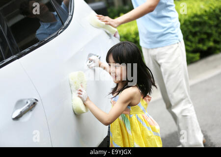 Girl helping father cleaning car Stock Photo