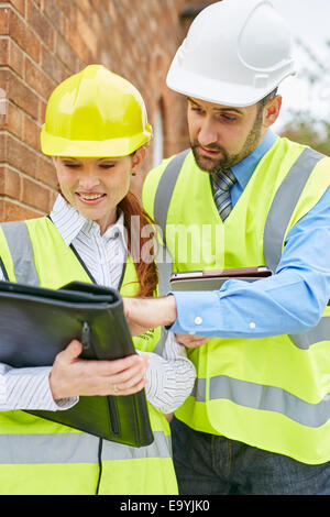 Architects discussing plans at a building site Stock Photo