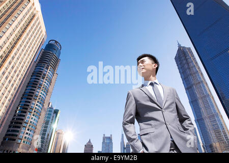 Young business man standing buildings in the middle Stock Photo