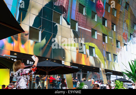 Woman taking photo of vibrant ceiling in the Markthal. Stock Photo